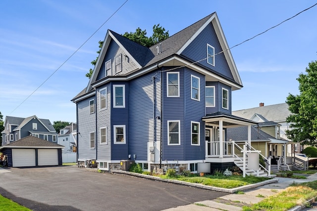 view of front of house featuring a garage, an outdoor structure, and central AC