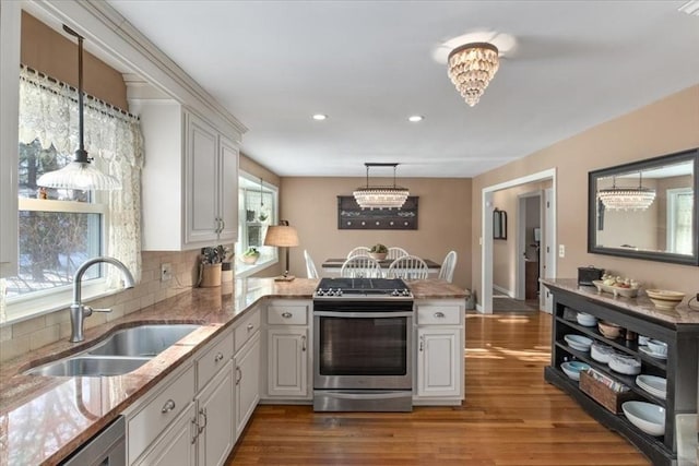 kitchen featuring stainless steel appliances, hanging light fixtures, and white cabinets