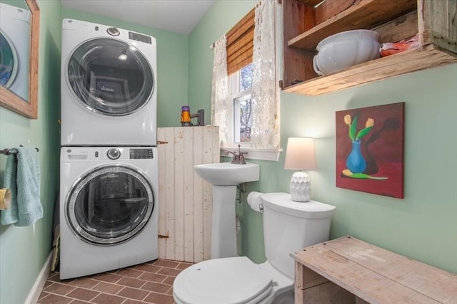 clothes washing area featuring sink and stacked washer / dryer