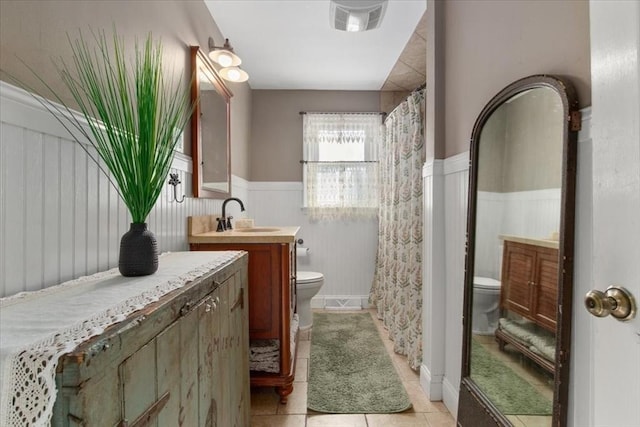 bathroom featuring vanity, curtained shower, tile patterned floors, and toilet