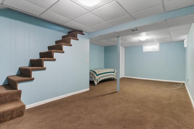 basement with dark colored carpet and a paneled ceiling