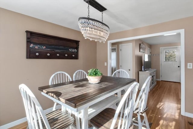 dining room featuring wood-type flooring and a chandelier