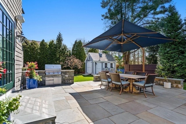 view of patio with a grill, an outbuilding, and exterior kitchen