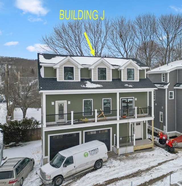 view of front of property with a garage, a balcony, and roof with shingles