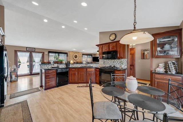 kitchen with dark countertops, a peninsula, recessed lighting, decorative backsplash, and black appliances