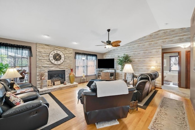 living room featuring ceiling fan, vaulted ceiling, and a wealth of natural light