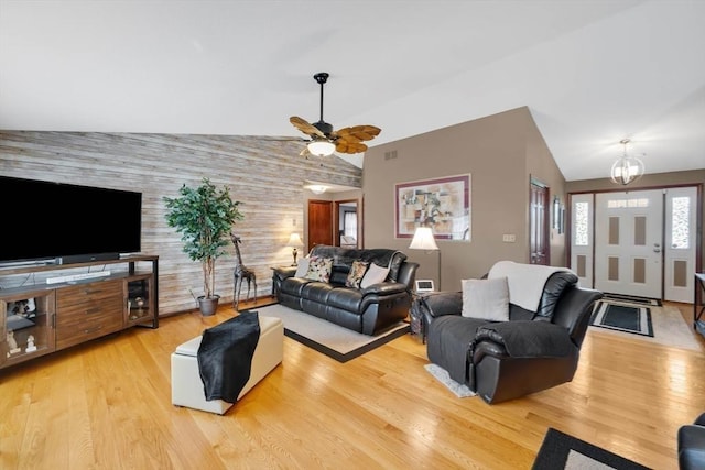 living area featuring ceiling fan, wood finished floors, and lofted ceiling