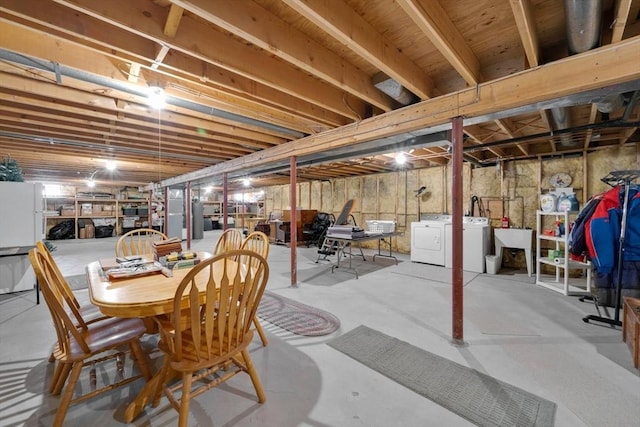 unfinished below grade area with washing machine and clothes dryer and freestanding refrigerator
