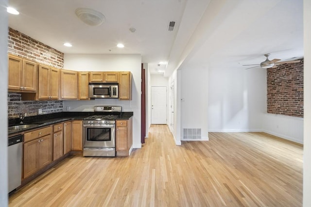 kitchen with light wood finished floors, a ceiling fan, a sink, visible vents, and appliances with stainless steel finishes