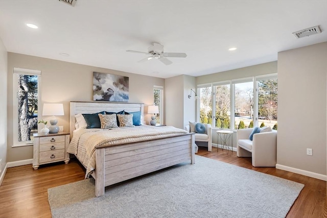 bedroom with ceiling fan, recessed lighting, wood finished floors, visible vents, and baseboards