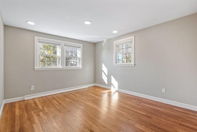 spare room featuring baseboards, baseboard heating, wood finished floors, and recessed lighting