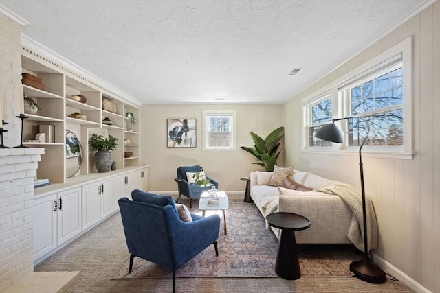 sitting room featuring visible vents, crown molding, a textured ceiling, and baseboards