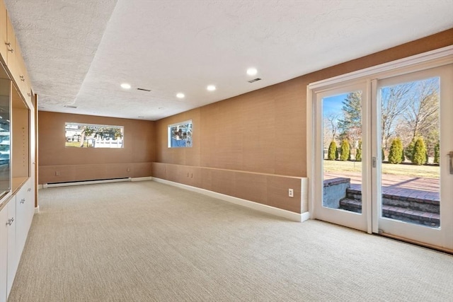 unfurnished room featuring recessed lighting, light colored carpet, a baseboard heating unit, a textured ceiling, and baseboards