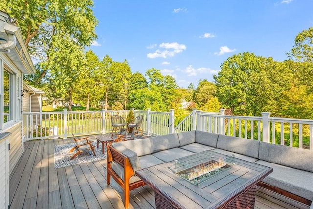 wooden deck featuring an outdoor living space with a fire pit