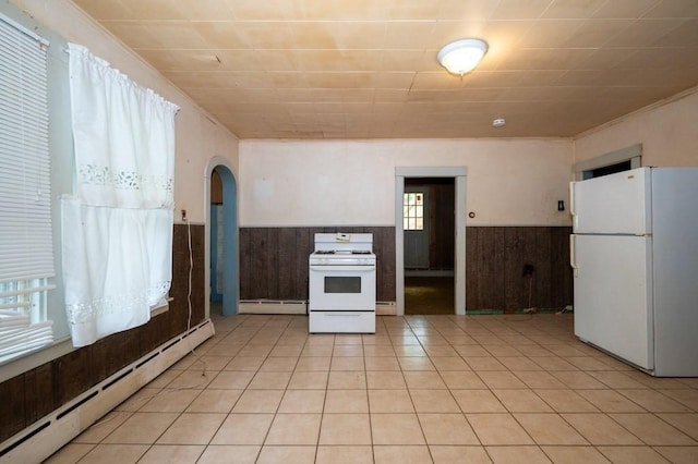 127 Cliff St, Southbridge, MA 01550 - kitchen featuring white appliances, a baseboard heating unit, wainscoting, wood walls, and arched walkways