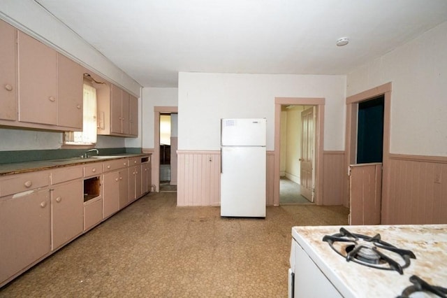 127 Cliff St, Southbridge, MA 01550 - kitchen with white appliances, a wainscoted wall, light countertops, and a sink