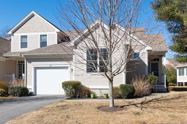 view of front of house featuring driveway, roof with shingles, and an attached garage