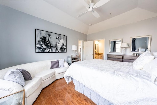 bedroom featuring lofted ceiling, connected bathroom, light wood-style flooring, and ceiling fan