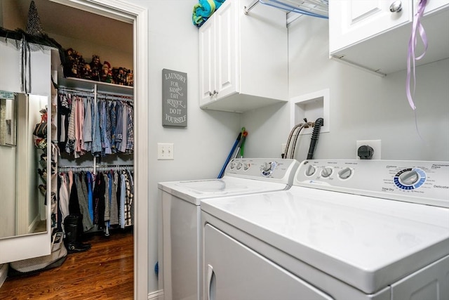 clothes washing area with dark wood finished floors, cabinet space, and washer and dryer