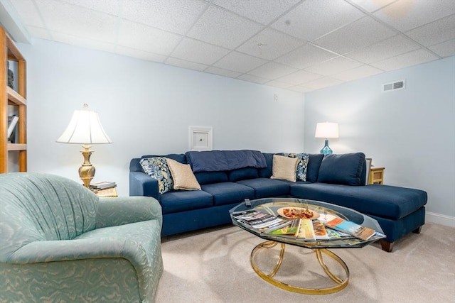 carpeted living room featuring baseboards, visible vents, and a drop ceiling