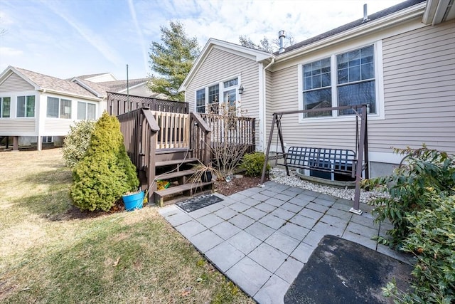 back of house with a patio area, a lawn, and a wooden deck