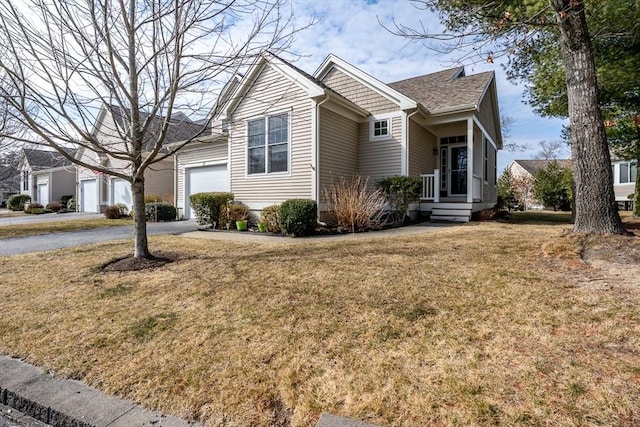 view of front of home with a garage, a front lawn, and aphalt driveway