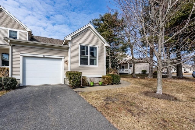 view of front of property with a garage, driveway, and roof with shingles