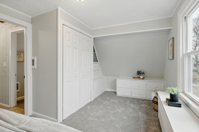 carpeted bedroom with a closet, baseboards, and a textured ceiling