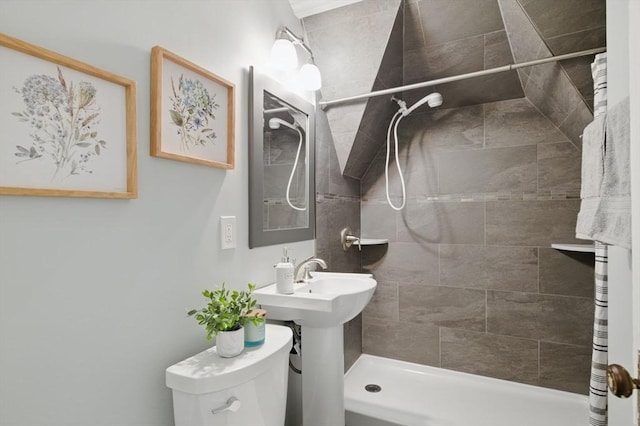 full bathroom featuring a tile shower and toilet