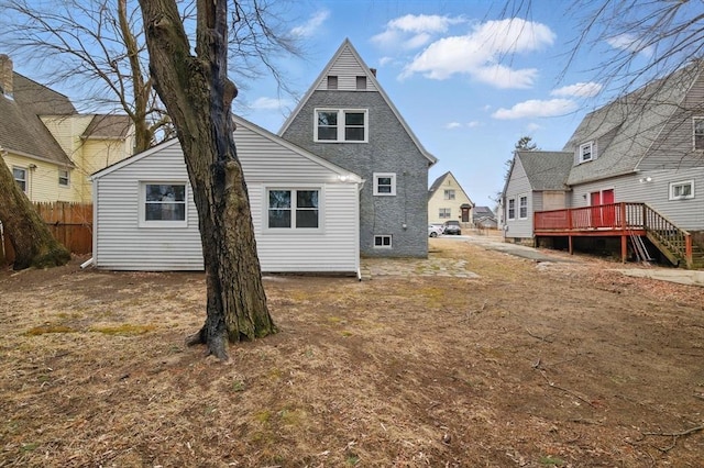 rear view of property with a deck and fence