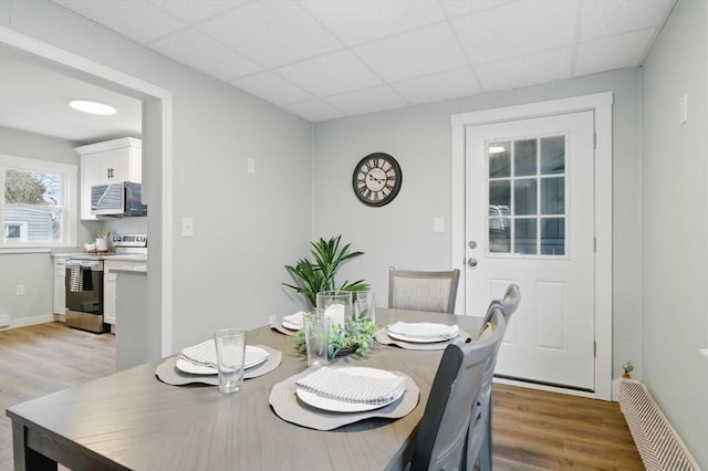 dining room with a drop ceiling and light wood-style floors