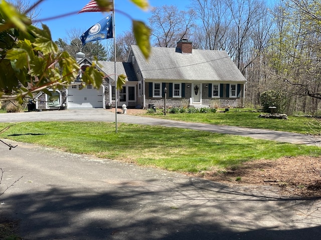 cape cod-style house featuring a garage and a front lawn