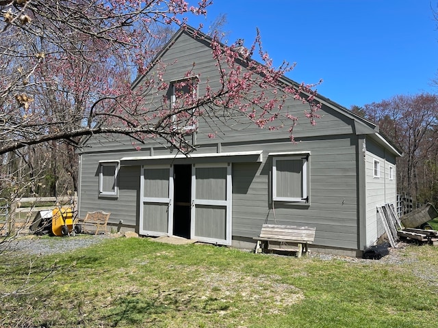 rear view of property with a yard and a storage unit