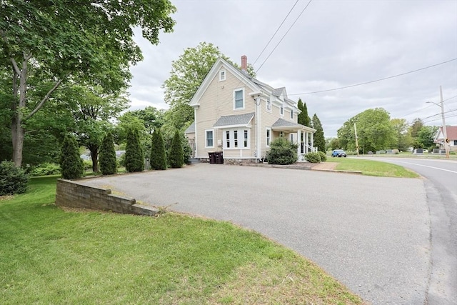 253 Front St, Weymouth, MA 02188 - view of front of house featuring a chimney, a front lawn, and asphalt driveway