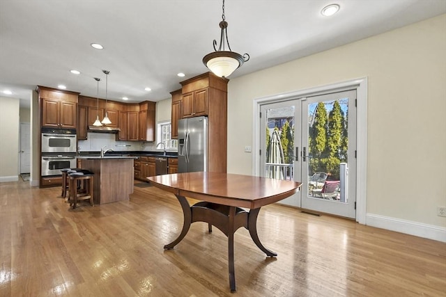 dining room with visible vents, baseboards, light wood-style flooring, and french doors