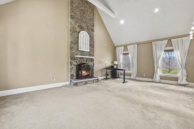 unfurnished living room featuring beamed ceiling, high vaulted ceiling, carpet floors, a stone fireplace, and baseboards