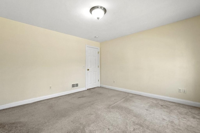 carpeted empty room featuring baseboards and visible vents