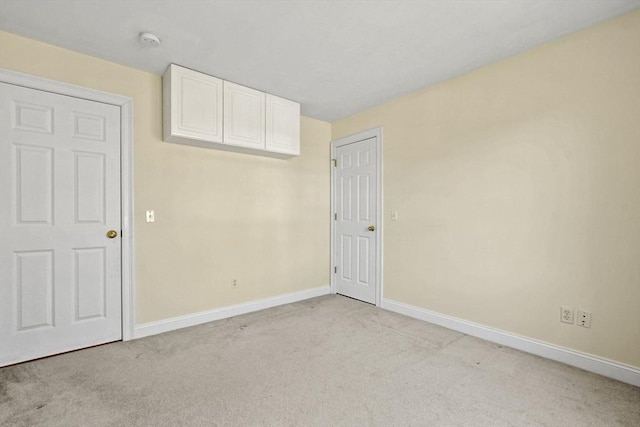 unfurnished bedroom featuring baseboards and light colored carpet