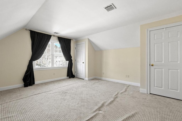 additional living space featuring baseboards, light carpet, and visible vents