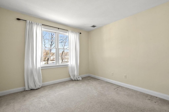 carpeted spare room featuring visible vents and baseboards