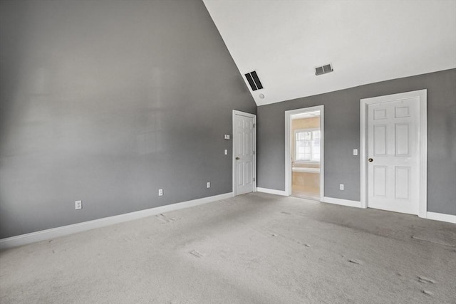 spare room featuring visible vents, carpet, baseboards, and high vaulted ceiling