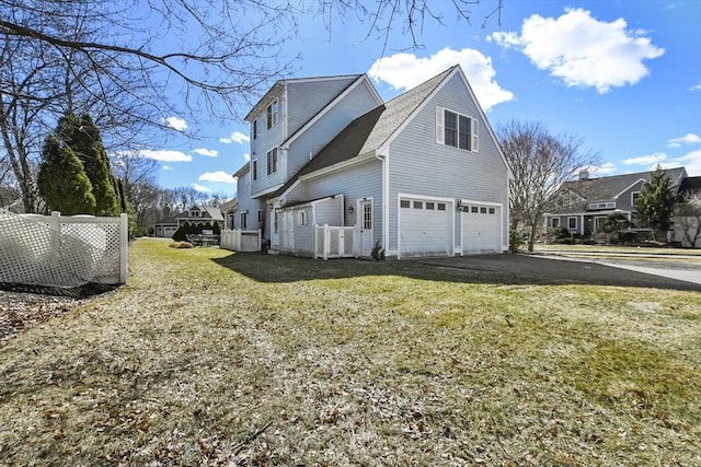 view of side of home with a garage, a yard, and driveway