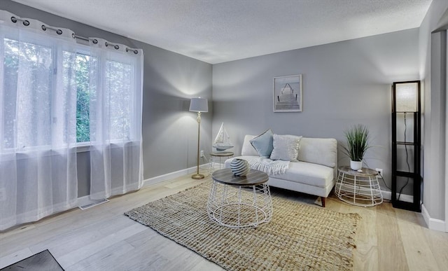 32 Sandy Reach Unit 32, Falmouth, MA 02536 - living room featuring visible vents, a textured ceiling, baseboards, and wood finished floors