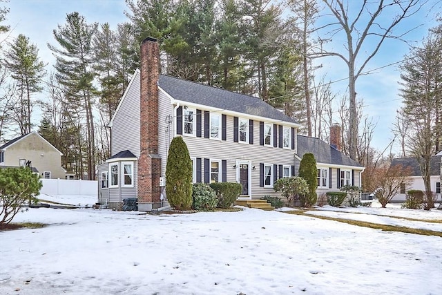 view of front of property with a chimney and fence