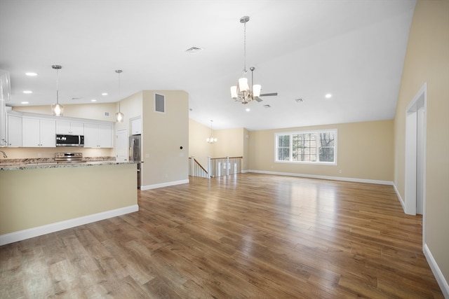 unfurnished living room featuring high vaulted ceiling, a chandelier, and hardwood / wood-style flooring