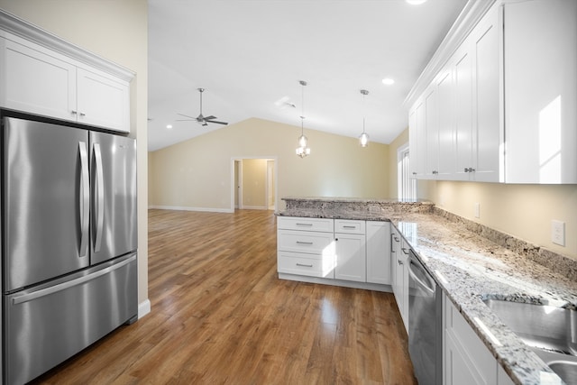 kitchen with vaulted ceiling, white cabinetry, appliances with stainless steel finishes, and dark wood-type flooring