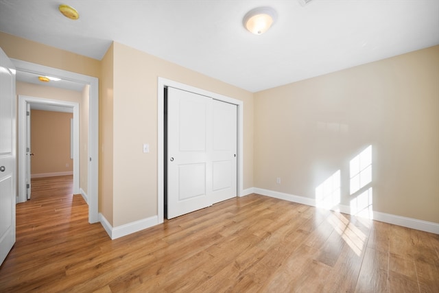 unfurnished bedroom featuring a closet and light hardwood / wood-style flooring