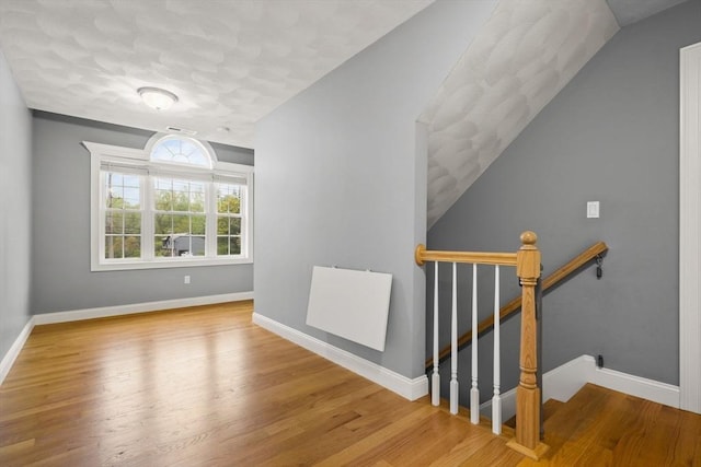 stairs with wood finished floors and baseboards
