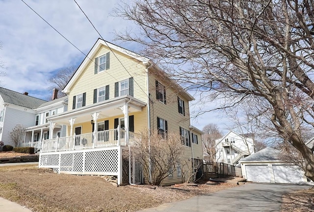 view of front of property featuring a porch, an outbuilding, and a detached garage