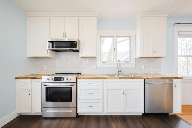 kitchen featuring a sink, white cabinets, appliances with stainless steel finishes, and wooden counters